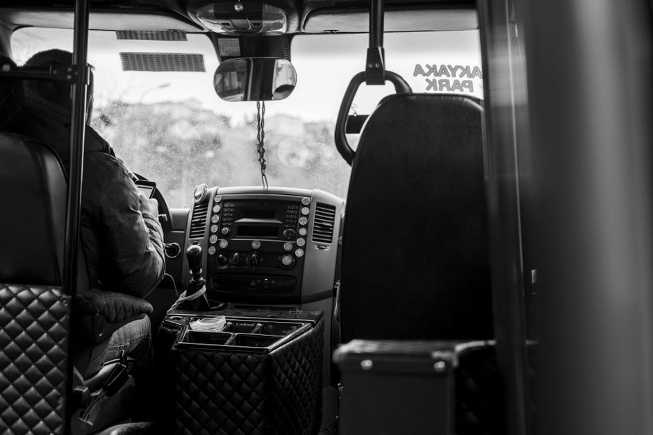 Een buschauffeur in uniforme kleding die passagiers verwelkomt aan de deur van een bus, klaar voor vertrek.
