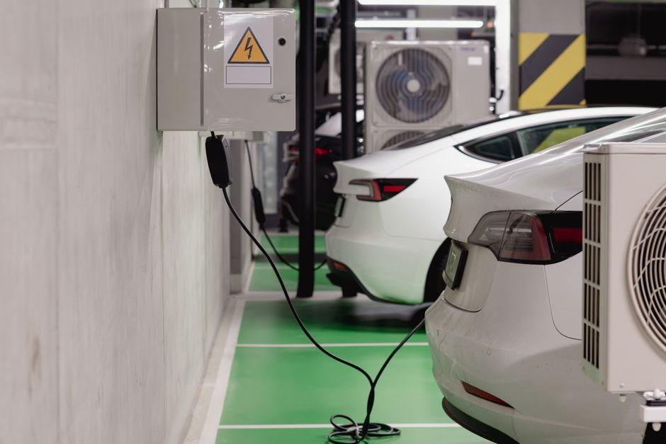 Een moderne zakelijke laadpaal voor elektrische voertuigen bij een bedrijf, omringd door groen en duurzaamheid.